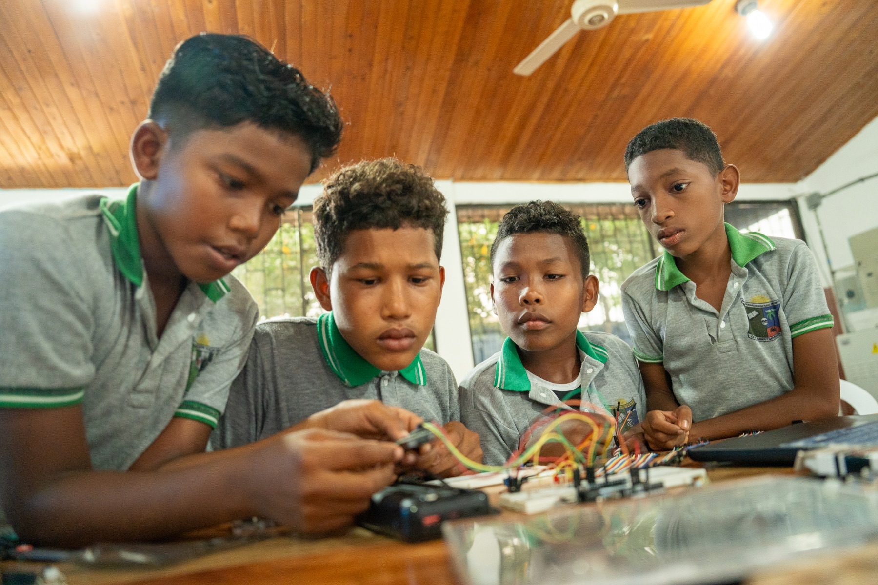 Cuatro estudiantes de la institución construyen juntos un prototipo electrónico en el aula.