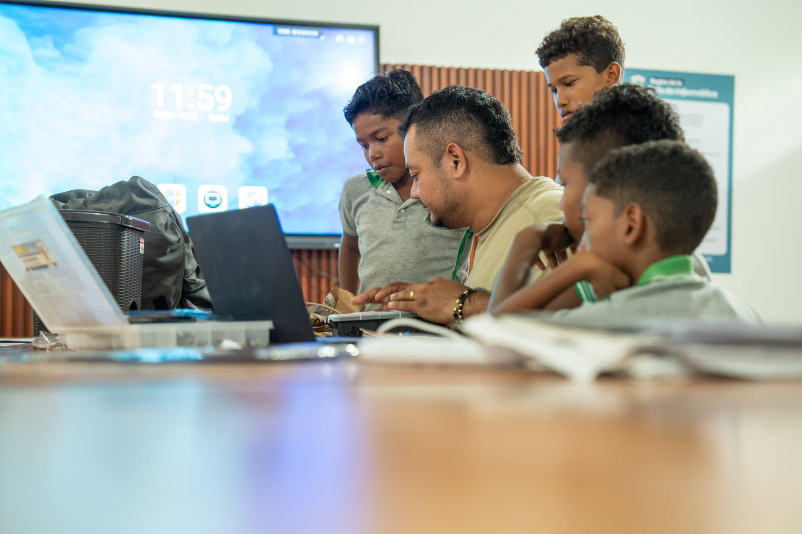 Equipo escolar consulta información en un portátil mientras organiza su prototipo.