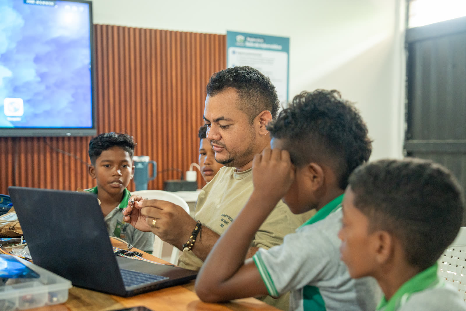 Un equipo escolar programa y prueba conexiones electrónicas junto a un computador.